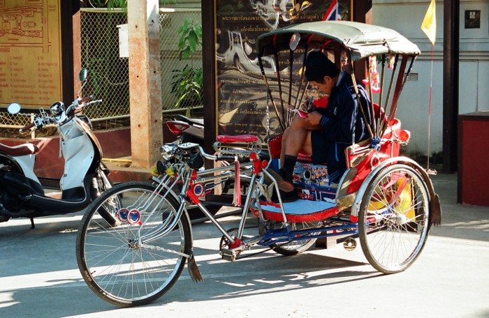 Photo d'un rickshaw avec son chauffeur.